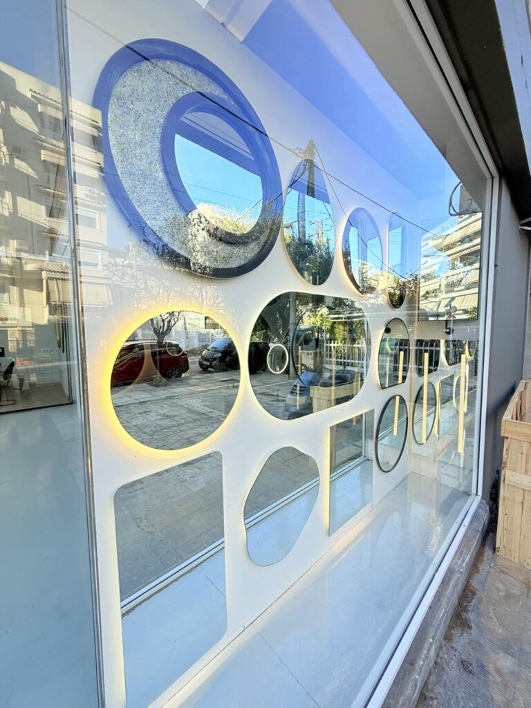 Σύνθετη κατασκευή καθρεπτών ειδικού σχεδιασμού με γεωμετρικό πλέγμα και πάνελ σε έκθεση καταστήματος, DNglass. Δείγμα custom καθρέπτη πάνω από διπλό έπιπλο μπάνιου.